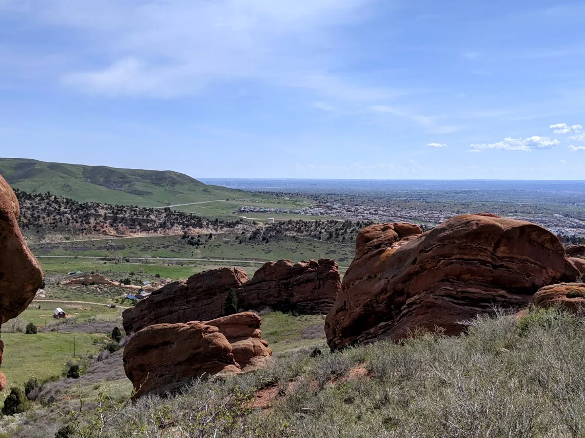 Red sandstone formations overlooking green foothills